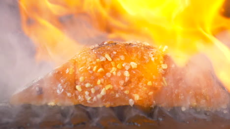 A-close-up-side-shot-of-barbecue-fish-flambe-with-gin-pouring-over-it-in-slow-motion