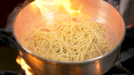 A-close-up-shot-of-flambe-pasta-being-tossed-in-slow-motion
