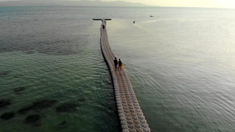 Drone-shot-of-a-couple-walking-on-a-floating-pier