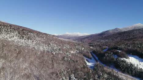 rising,-pulling-back-and-panning-drone-shot-of-winter-mountain-valley-with-river-and-road
