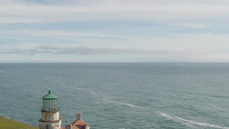 Historic-lighthouse-on-coast,-drone-reveal