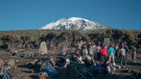 Zeitraffer-Des-Abrisses-Des-Lagers,-Dann-Der-Kippzeremonie-Und-Der-Abreise-Mit-Den-Trägern-Und-Der-Besatzung-Unter-Dem-Kilimandscharo-In-Tansania