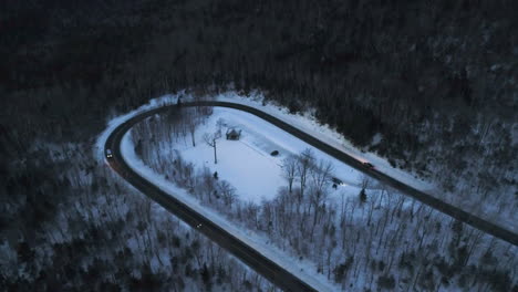 drone-video-at-dusk-in-the-mountains-with-cars-driving-around-a-hairpin