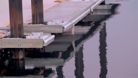 Close-up-of-dock-edge-floating-on-water,-early-morning