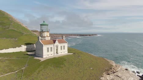 Historic-lighthouse-on-cliff-side,-drone-pull-away-to-reveal-Point-Conception