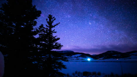 Starlapse-of-Blue-and-Purples-on-the-Snow-with-Silhouetted-Trees-to-Look-Up-Intro-the-Blurry-Sky