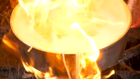 a-close-up-shot-of-a-pan-on-fire-with-flambe-pasta-in-slow-motion