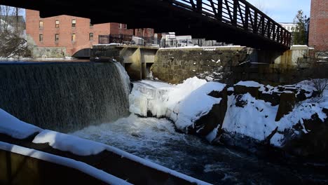 wide-angle-view-of-dam-with-ice-and-rocks-and-bridge