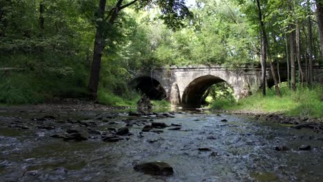 Slow-Tilt-Up-Shot-of-River-and-OId-Stone-Bridge