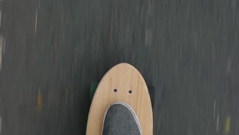 Close-up-top-POV-shot-of-a-skater-playing-skateboard-or-cruiser-board-on-asphalt