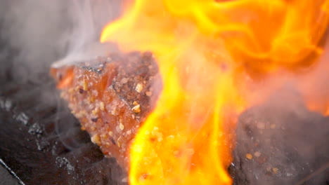 A-close-up-shot-from-the-top-of-barbecue-flambe-salted-fish-with-gin-poured-on-it-in-slow-motion