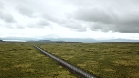 Tiro-De-Podio-Hacia-Arriba-De-La-Carretera-1-En-Islandia-Que-Muestra-Un-Hermoso-Lago-En-El-Fondo-Entre-Algunas-Hermosas-Montañas