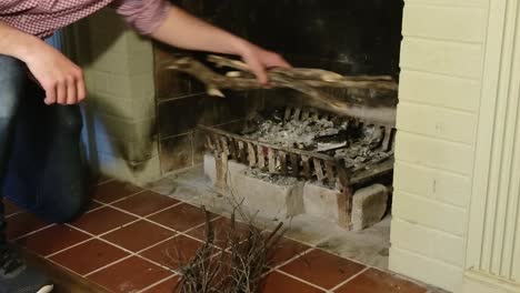 Man-Prepares-Fireplace-with-Small-Pieces-of-Wood