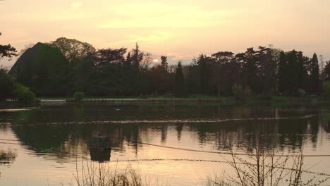 A-static-shot-of-the-sunset-over-the-lake-in-the-Vincennes-Woods-in-Paris