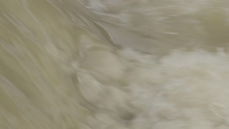 Slow-motion-shot,-full-frame-of-dirty-brown-water-with-lot-of-splashes-from-a-small-waterfall