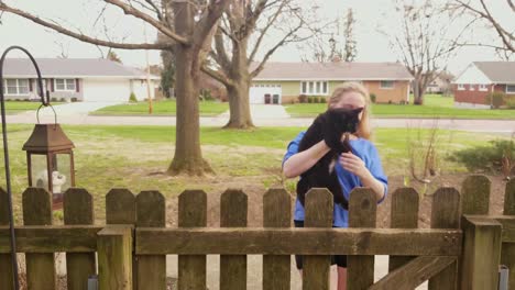 Woman-Brings-Her-Small-Black-Cat-Back-Into-Gate
