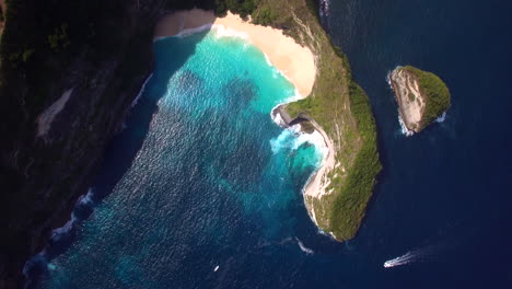 drone-flying-forward-above-kelingking-beach-on-nusa-penida-island-green-peninsula-yellow-sand