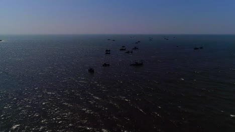 Drone-footage-moving-towards-a-group-of-fishing-boats-in-open-sea