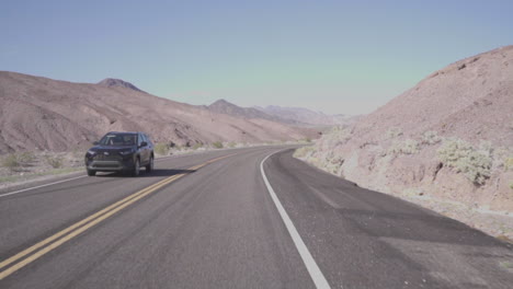 Driving-Along-A-Desert-Road-Slow-Motion-Car-Drives-Past