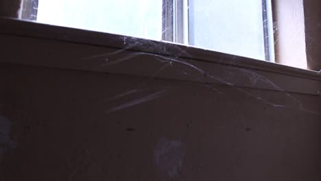 Verlassenes-Fensterlicht,-Das-Durch-Spinnweben-Scheint,-Schwenkt-Gruselig