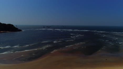 Drone-footage-moving-forwards-towards-sea-and-hills-touching-the-waves-,-shot-in-south-GOA,-India