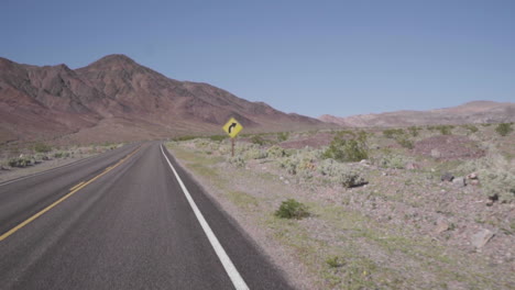 Driving-Past-A-Road-Sign-In-The-Desert-Slow-Motion