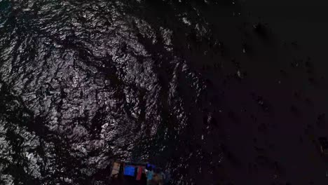 Drone-footage-moving-forwards-looking-down-at-fishing-boats-in-sea-panning-up-to-reveal-the-open-sea