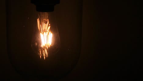 Turn-On-incandescent-light-bulb-filament-at-hotel-drama-with-dark-mystery-wallpaper-background-black-on-left