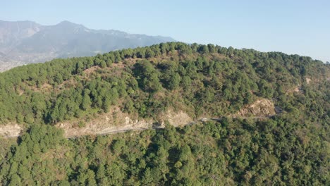 Drohnenaufnahmen-Einer-Straße-In-Wunderschönen-Hügeln-Im-Wald-Im-Himalaya-In-Indien