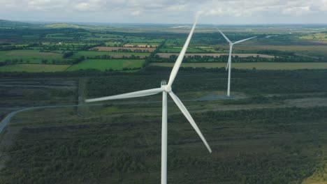 Aerial-view-of-Wind-turbine-farm-over-the-Irish-landscape,-Energy-Production--4k-aerial-shot