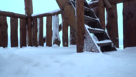 Männliche-Füße,-Die-Holztreppen-Auf-Der-Aussichtsplattform-Hinaufgehen,-Im-Winter-Eingeschneit