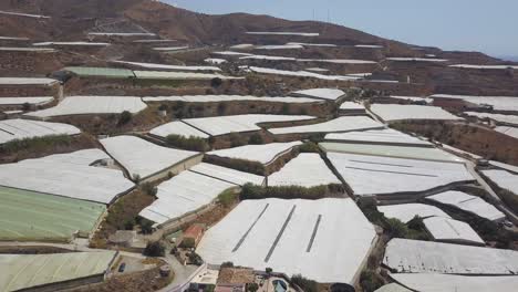 Aerial-shot-of-greenhouses-in-different-levels-of-a-mountain-in-the-south-of-Spain