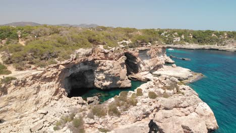 Spain-Mallorca-Cala-Llombards-and-Cala-Santanyi-at-4k-24fps-with-ND-filters-flying-with-a-DJI-Mavic-Air-with-beautiful-views-of-the-beaches,-rocks,-boats-and-blue-water
