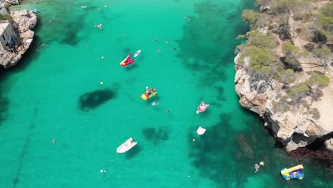 Spain-Mallorca-Cala-Llombards-and-Cala-Santanyi-at-4k-24fps-with-ND-filters-flying-with-a-DJI-Mavic-Air-with-beautiful-views-of-the-beaches,-rocks,-boats-and-blue-water