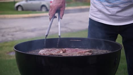 Flipping-steak-on-grill---BBQ-outdoor
