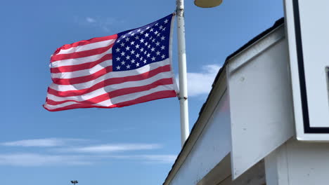 A-tattered-American-flag-blows-in-the-breeze-in-Cape-Cod-on-a-summer-day