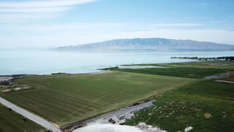 Tiro-De-Drone-Volando-Sobre-Algunas-Tierras-De-Cultivo-De-Utah-Hacia-El-Gran-Lago-De-Utah