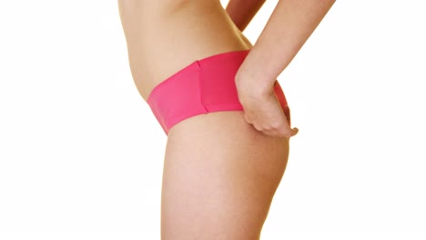 The-woman-corrects-pink-panties-on-the-buttocks