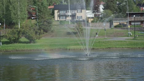 Static-shot-of-a-medium-sized-fountain-in-a-small-lake-pond