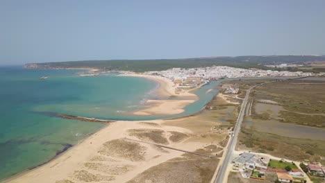 Luftaufnahme-Des-Strandes-Von-Barbate-Mit-Der-Weißen-Stadt-Und-Dem-Dahinter-Liegenden-Hügel-In-Spanien