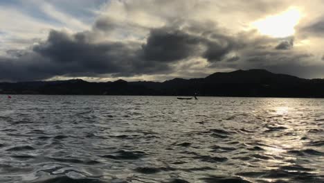 Kayak-moored-in-the-middle-of-rippling-water-at-the-Little-Omaha-inlet-in-new-Zealand-during-a-cloudy-sunset