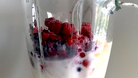 Blending-wild-frozen-berries-with-milk-and-honey-in-an-electric-blender-into-a-smoothie