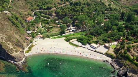 Aerial-shot-of-a-beach-with-people-near-Collioure-at-the-Mediterranean-Sea-during-a-hot-summer-day