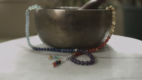 Slow-push-in-shot-of-a-Tibetan-singing-bowl-with-mala-prayer-beads-slider-shot-in-4K-UHD