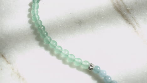 Macro-dolly-shot-of-crystal-green-aventurine-beads-from-a-Tibetan-prayer-mala-shot-in-UHD-4K