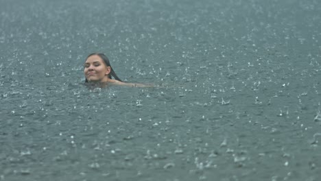 Eine-Junge-Frau,-Die-Freiheit-Ausdrückt,-Schwimmt-Draußen-Im-Offenen-Wasser-Im-Regenklima