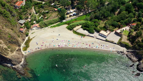 Toma-Aérea-De-Una-Playa-Con-Gente-Cerca-De-Collioure-En-El-Mar-Mediterráneo-Durante-Un-Caluroso-Día-De-Verano