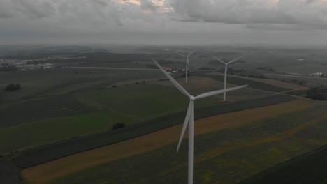 Luftaufnahme-Von-Windkraftanlagen,-Die-Während-Eines-Bewölkten-Sonnenaufgangs-Nach-Einem-Sturm-Am-Frühen-Morgen-Strom-Erzeugen