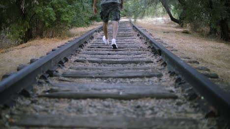 Slow-Motion-Shot-of-a-lonely-man-walking-on-abandoned-train-tracks