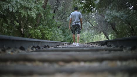 Slow-Motion-Shot-of-a-lonely-person-walking-on-abandoned-Train-Tracks